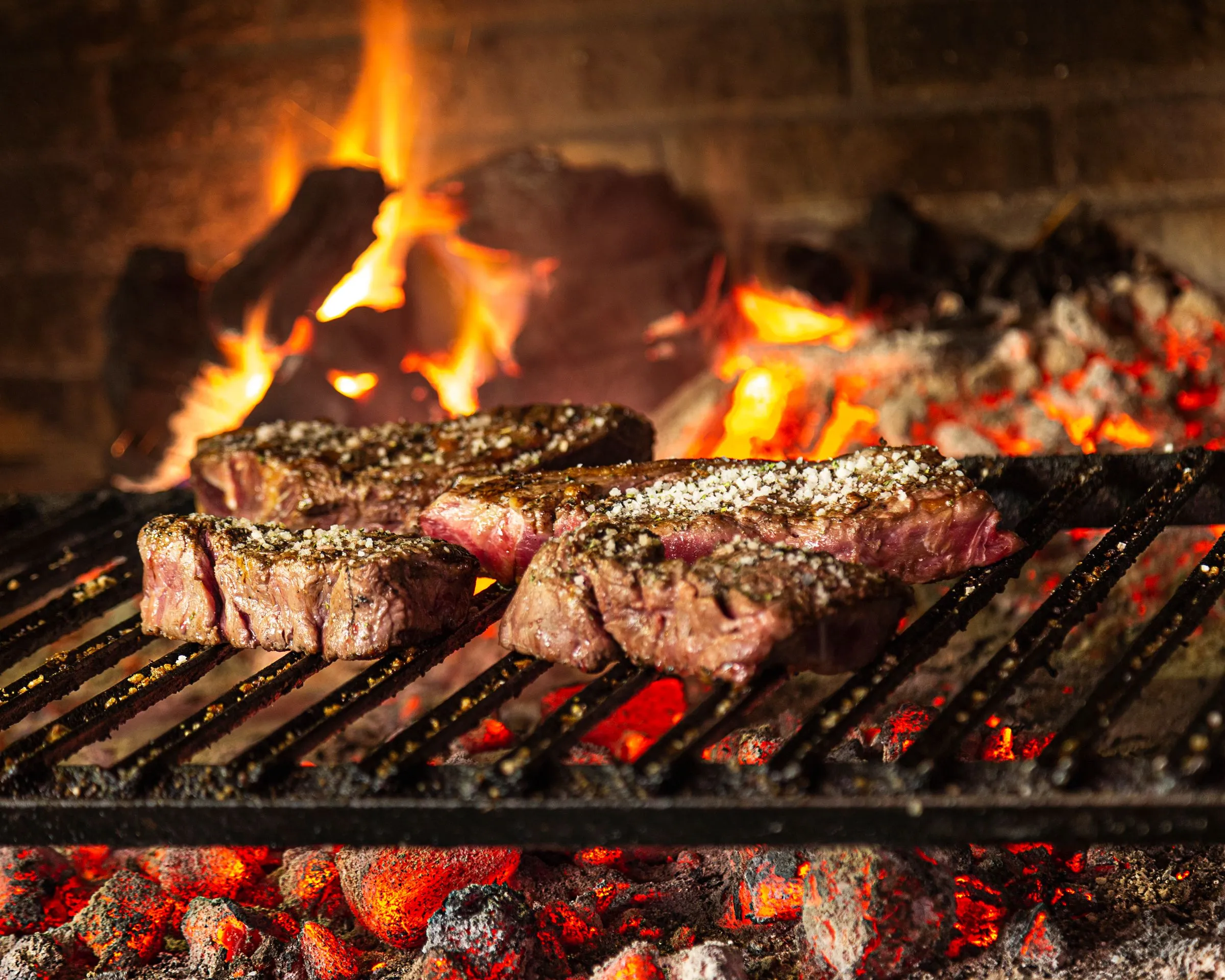 Txuletas asándose directamente sobre brasas incandescentes en la parrilla de Artebe